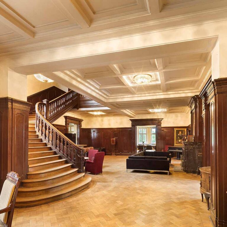 Geschwungene Holztreppe in der Empfangshalle